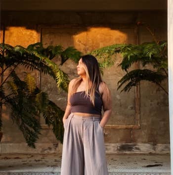 reviewer wearing the taupe pants with an asymmetrical top
