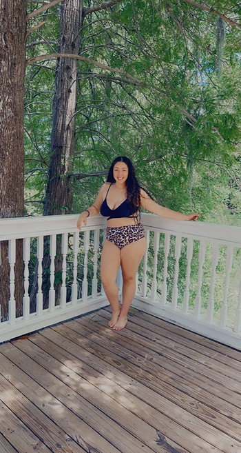 reviewer wearing the suit with a black top and cheetah print bottom