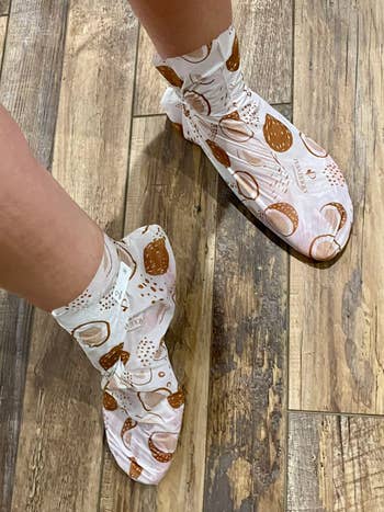 Person wearing moisture fastener socks with a printed plan portion lasting connected a woody floor