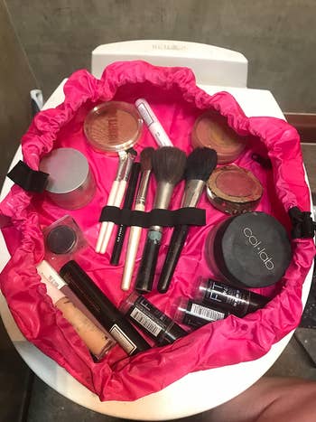 the open bag lying flat with all the makeup in it 