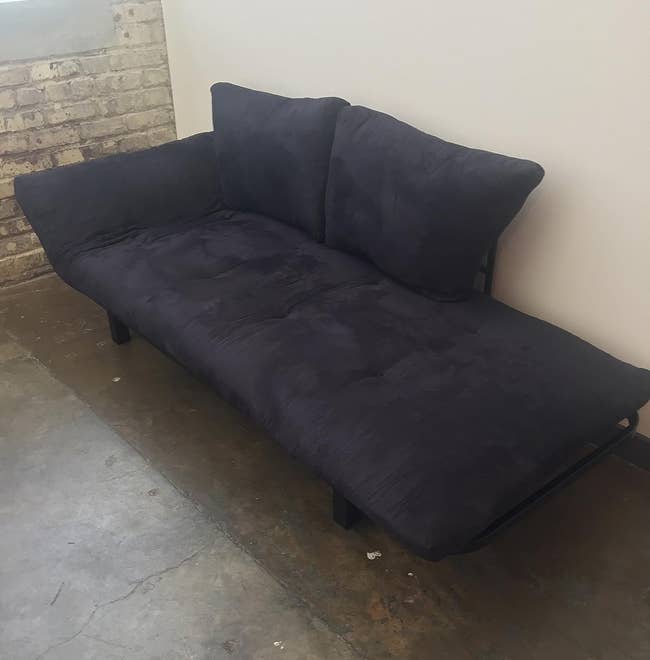 reviewer's black futon with one end in the down position