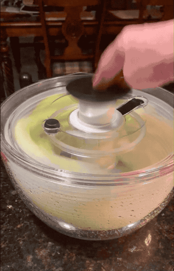 a gif of a reviewer spinning lettuce in the salad spinner 