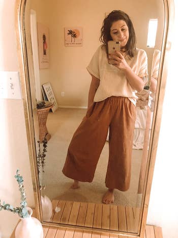 reviewer wearing the blouse with wide pants
