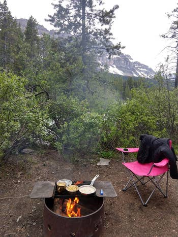 reviewer photo using cooking set to cook over campfire on campground