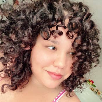 Person with brown curly hair after using Garnier shampoo and conditioner 