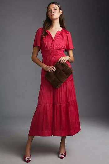 Model in a red short-sleeved cinch-waited peasant collared maxi dress 