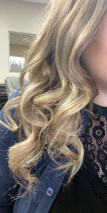 Reviewer with blonde curled hair and a denim shirt and black lace top