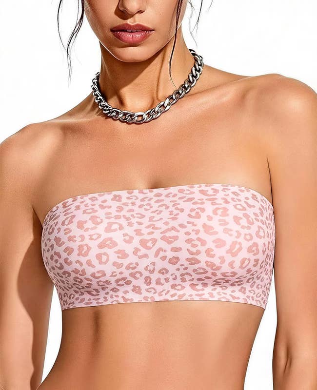 Person wearing a strapless, leopard people apical paired with a chunky concatenation necklace