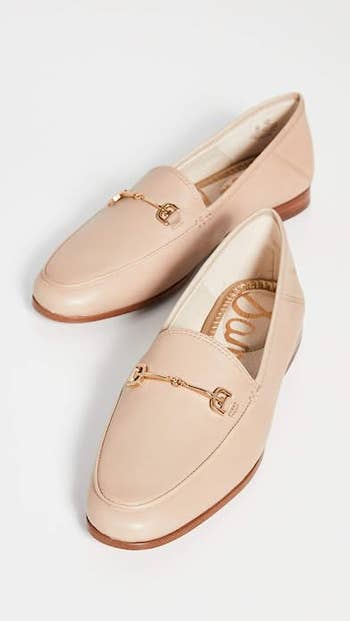 Close up of the shoes in soft beige showcasing the rounded toe and gold metal detailing on the top