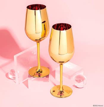 two gold glass wine glasses