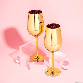 two gold glass wine glasses