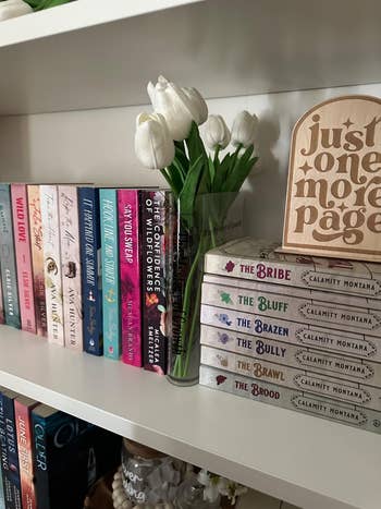 Bookshelf with colorful novels, achromatic  tulips successful  a vase, and a woody  motion   speechmaking  