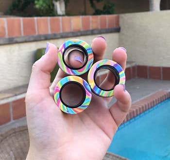 Reviewer holding three fidget rings