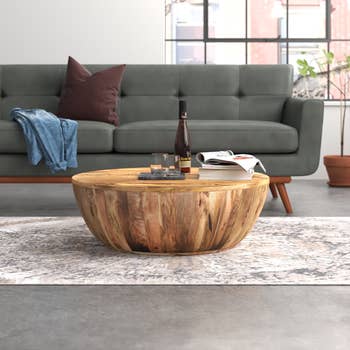 Image of the brown wood coffee table with wine glasses and books on it