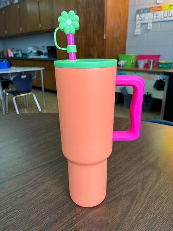 bright orange tumbler with green lid and pink handle