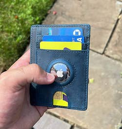 Reviewer holding their wallet with their AirTag attached to the wallet