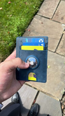 Reviewer holding their wallet with their AirTag attached to the wallet