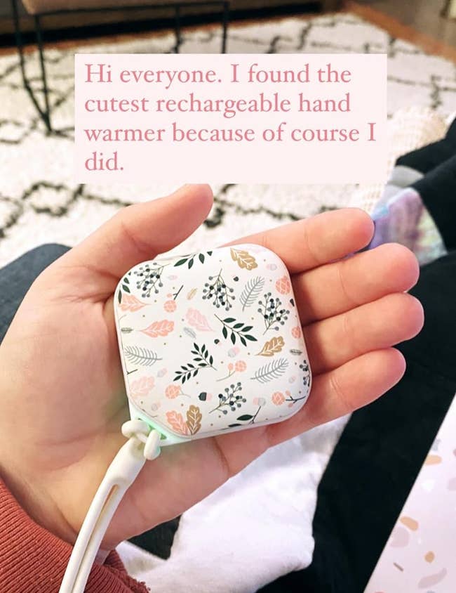 A reviewer holding the hand warmer in flower pattern