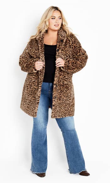 a model wearing the same coat with the full animal print side showing 