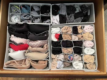 same reviewer's after photo showing the drawer looking much neater now that the socks, bras, and underwear have been organized using the dividers