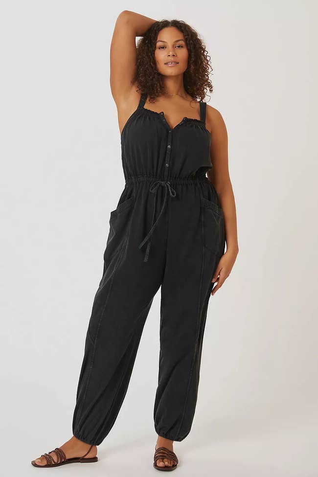 A model posing in the black jumpsuit