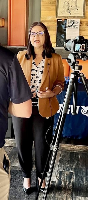 a reviewer wearing the pants with a blazer that looks to be at work