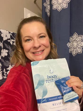 a reviewer holding the bag of shower steamers