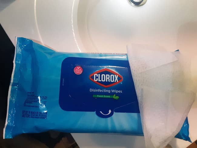 reviewer's blue package of wipes on a sink, with one wipe resting on the package