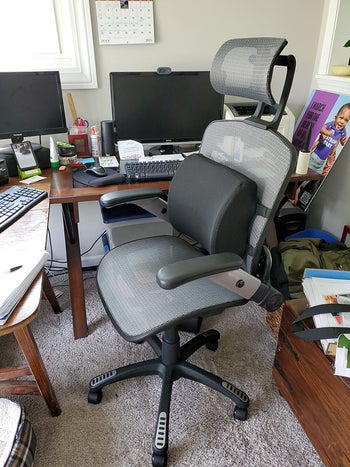 reviewer pic of the same chair shown in an office setup with a lumbar pillow attached