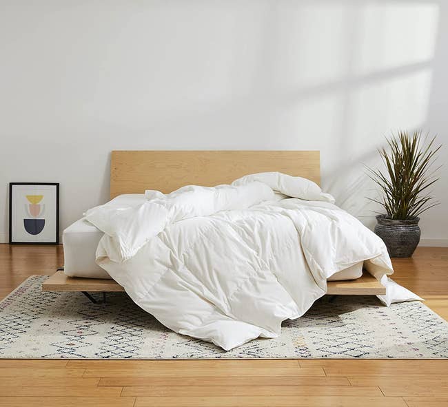 the down comforter on a wooden bed frame