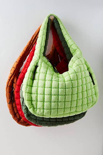 several bags in different colors hanging on a hook