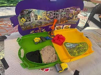 Toy operation  playset with digger and conveyance  connected  a foldable committee  featuring a metropolis  backdrop, sandpit, and excavator accessories