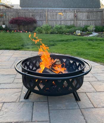 reviewer photo of the lit fire pit on a patio during the day