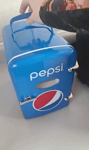 Reviewer opening blue mini fridge with Pepsi logo on it