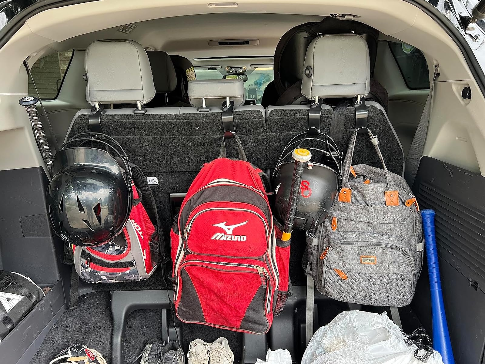 Batang mobil sarat dengan perlengkapan baseball, termasuk tas, helm, kelelawar, dan perlengkapan. Ideal untuk mengatur peralatan olahraga selama perjalanan belanja