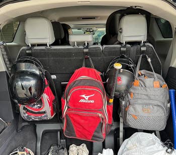 Batang mobil sarat dengan perlengkapan baseball, termasuk tas, helm, kelelawar, dan perlengkapan. Ideal untuk mengatur peralatan olahraga selama perjalanan belanja