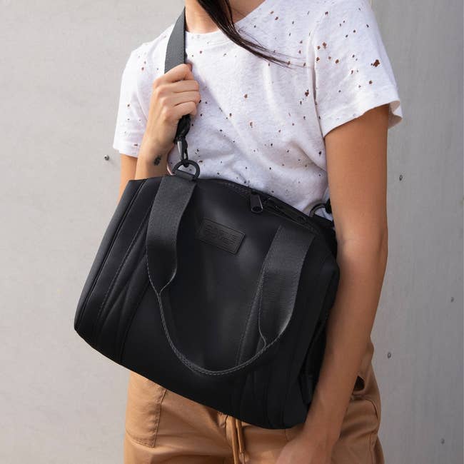 model holding a black Dagne dover bag
