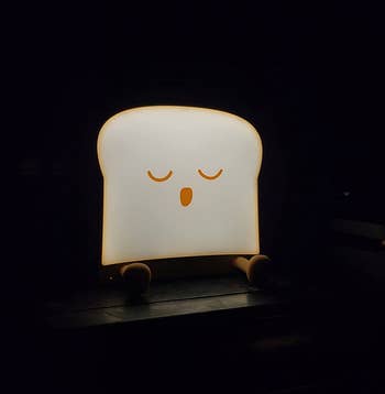 reviewer's sleeping toast night light illuminated in a dark room
