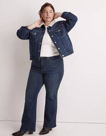 model wearing the denim jacket with a white top, jeans, and boots