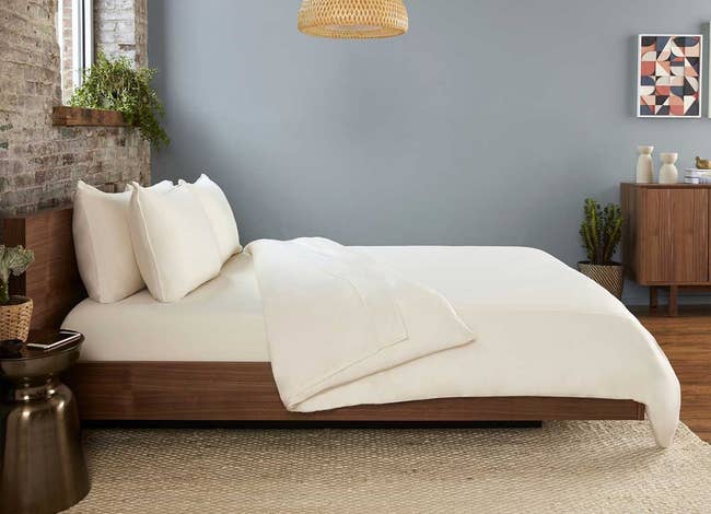 a bed made with the beige sheet set