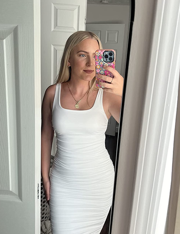 reviewer wearing the white dress