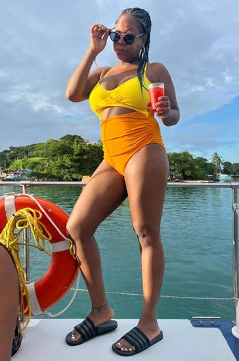 a reviewer wearing the same swimsuit with a yellow top portion and orange bottom portion 