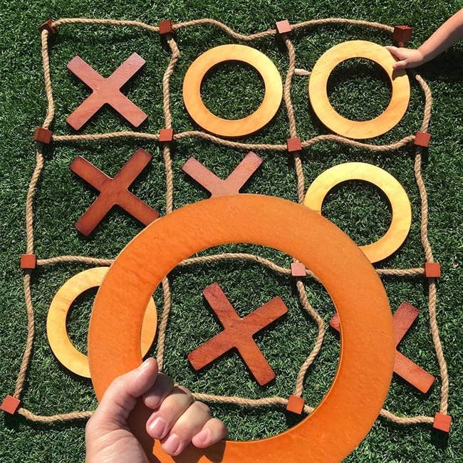 the rope board laid out with several wooden X and O pieces