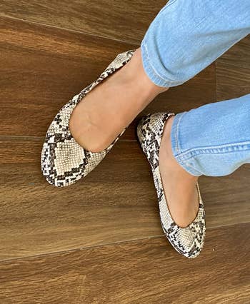 reviewer wearing snakeskin flats with jeans