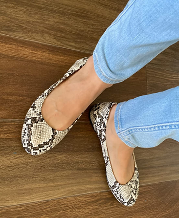 reviewer wearing snakeskin flats with jeans