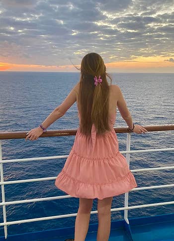 reviewer showing the back of the dress on a cruise boat