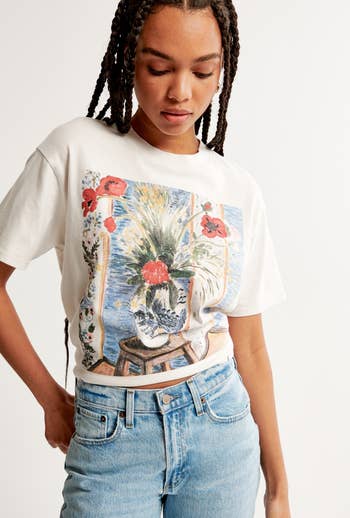 a model wearing the shirt rolled up as a crop top