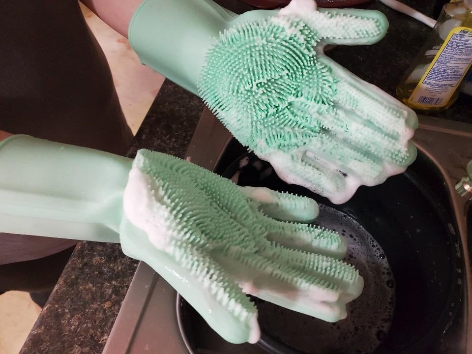reviewer's hands with cleaning bristle gloves on