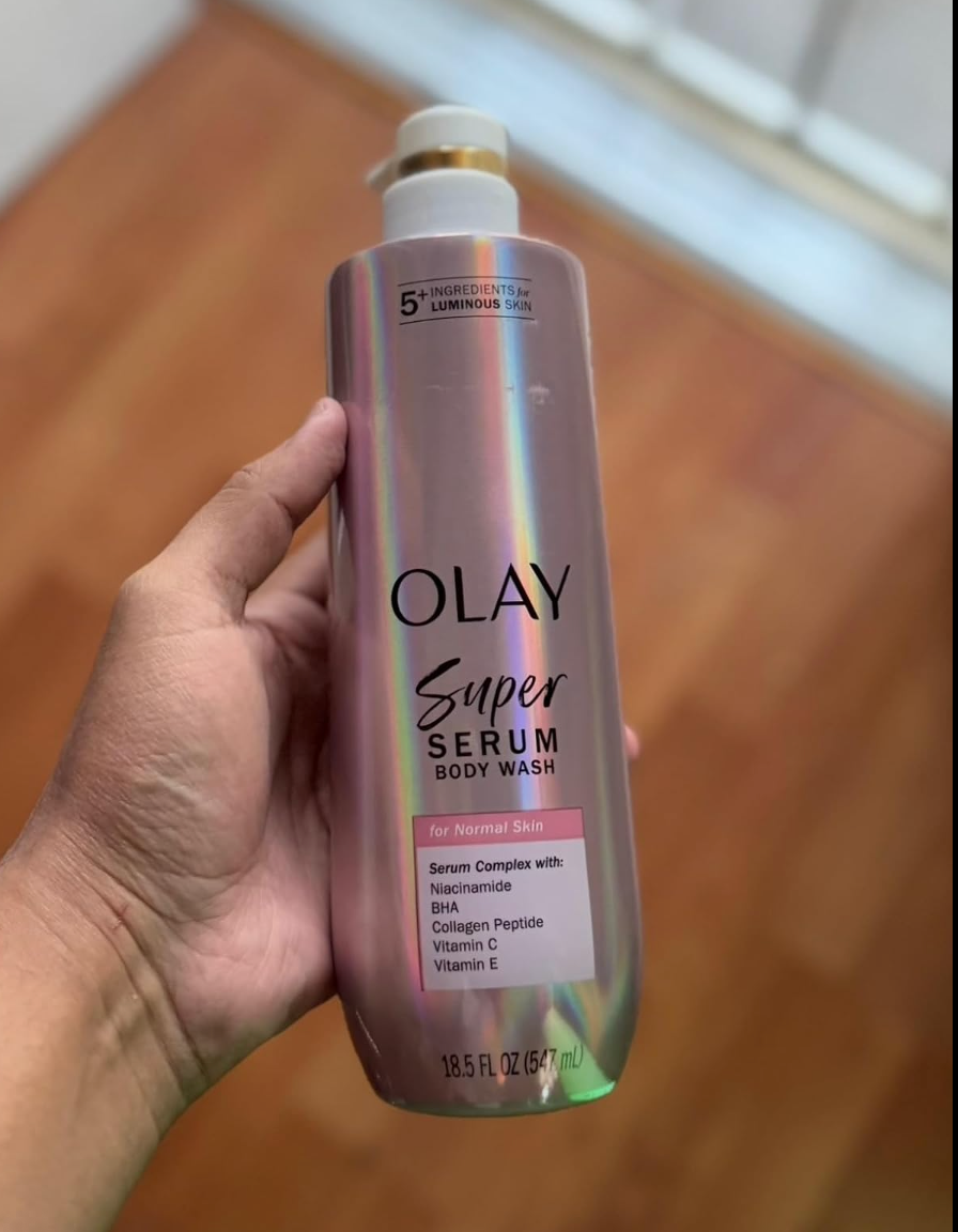 Person holding a bottle of Olay Super Serum Body Wash for normal skin with details of serum complex ingredients on the label