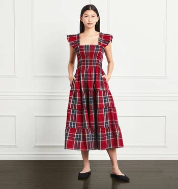 model wearing the red and green plaid dress with black flats